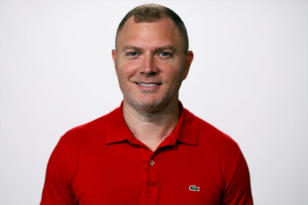 Headshot of Adam Steinfeld—a white man with short brown hair, wearing a red polo.