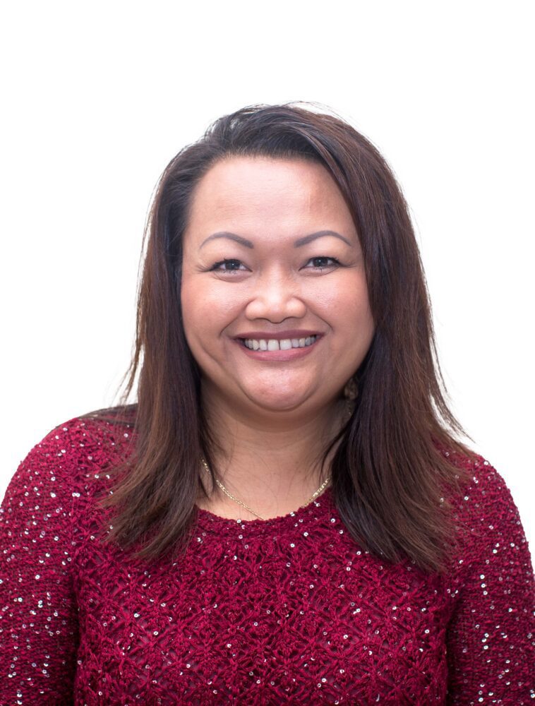 A headshot of Samnieng Hernandez—a woman with shoulder-length brown hair, wearing a red sequin dress.
