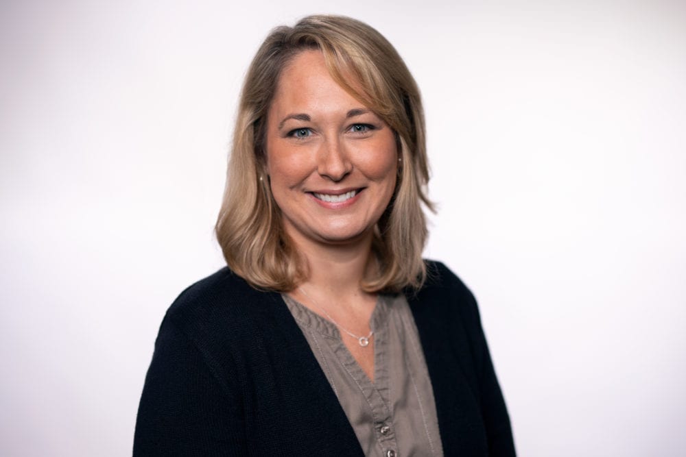 A headshot of Summer Westerberg—a white woman with short blonde hair, wearing a gray top underneath a black cardigan.